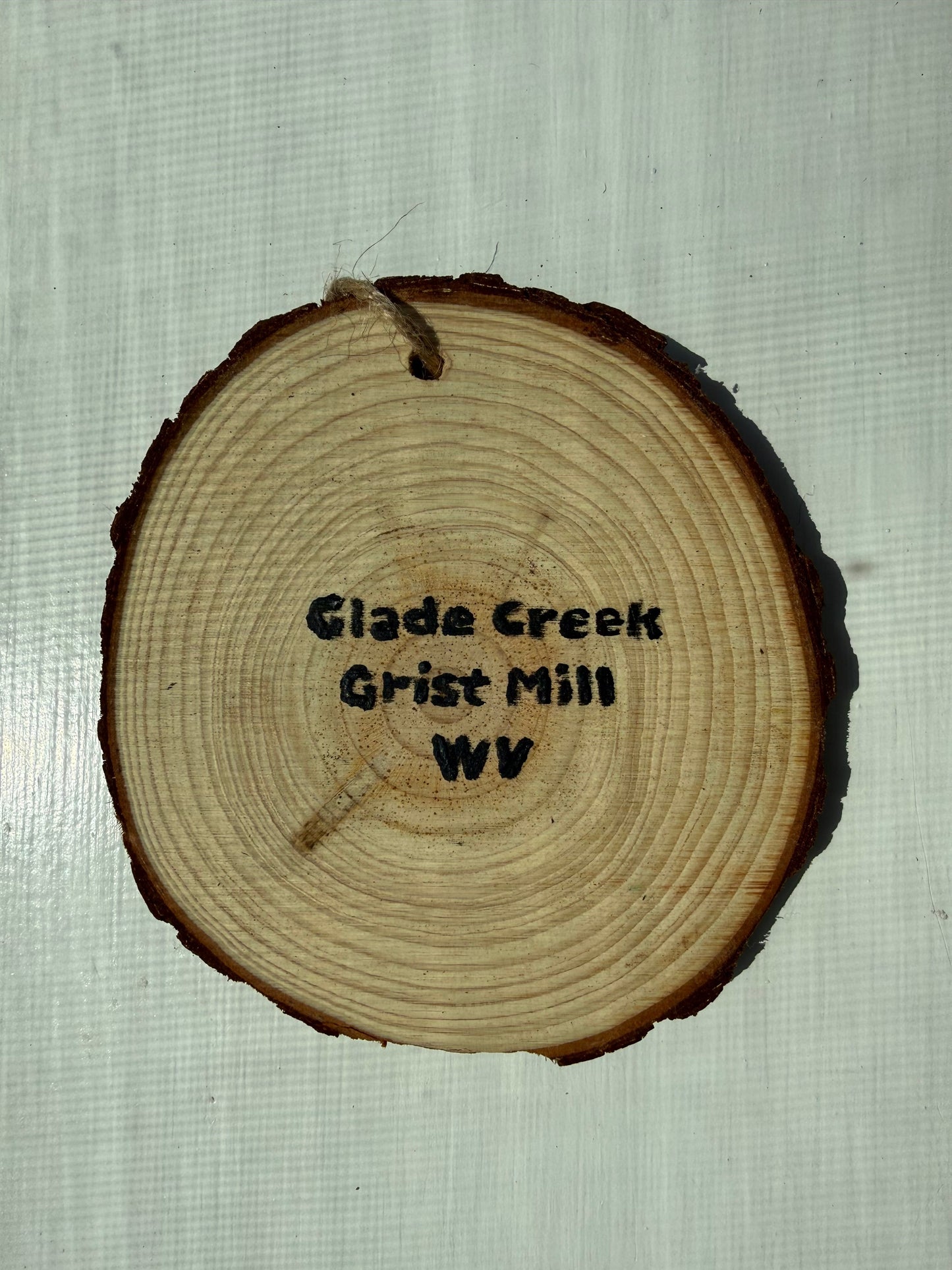 Wooden ornament with painted text that reads, "Glade Creek Grist Mill WV"