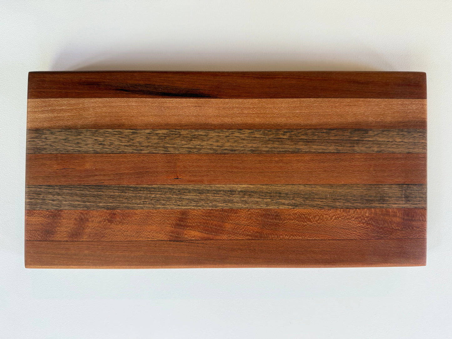 Wooden cutting board with a stripe pattern on a white surface