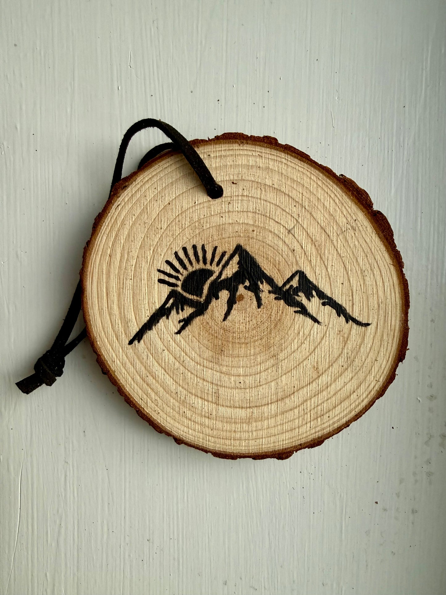 Wooden ornament featuring a black mountain design