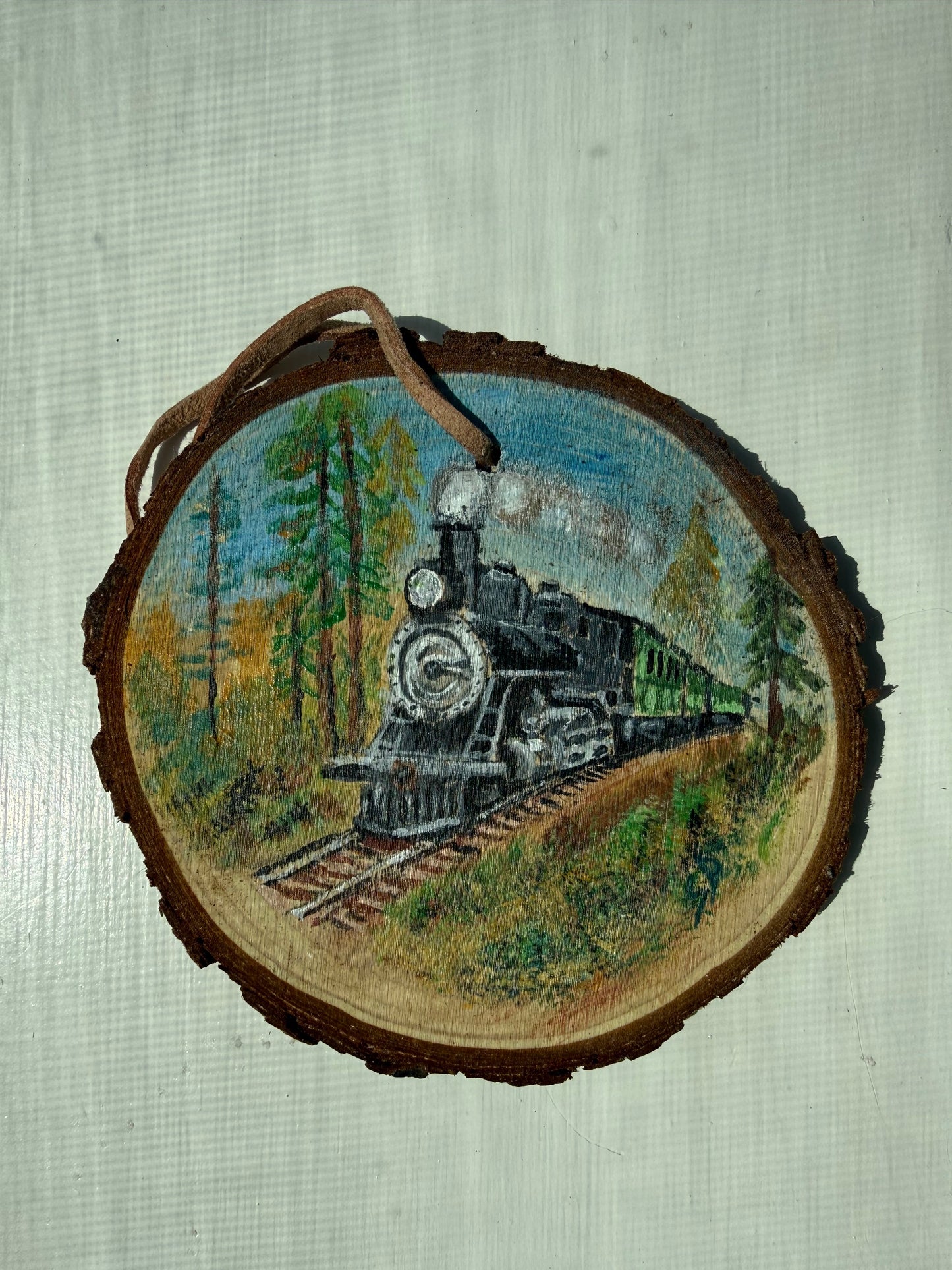 Wooden ornament with painted train on it