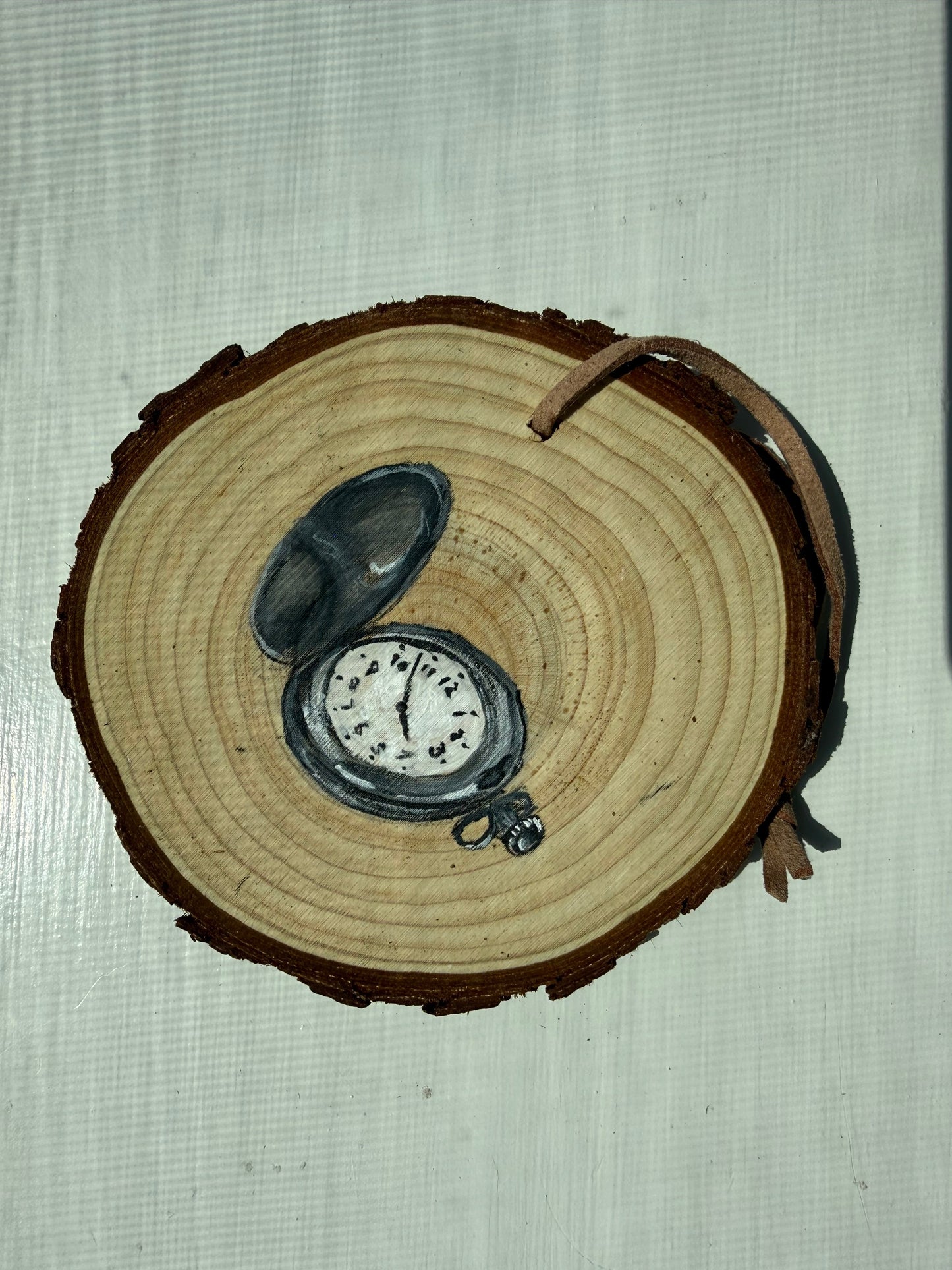 Wooden ornament with a painted pocket watch on it
