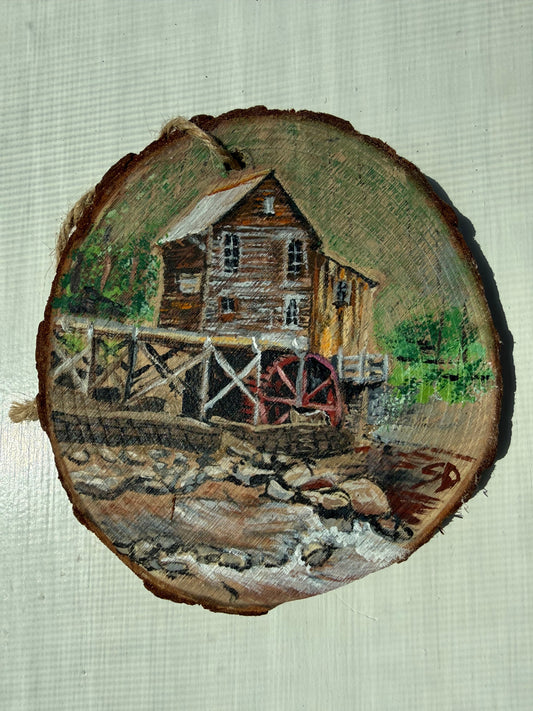 Wooden ornament with a painted scene of a mill