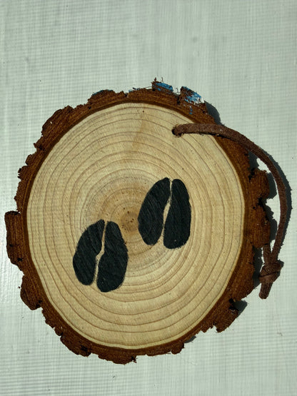 Wooden ornament with a painted design of black elk tracks