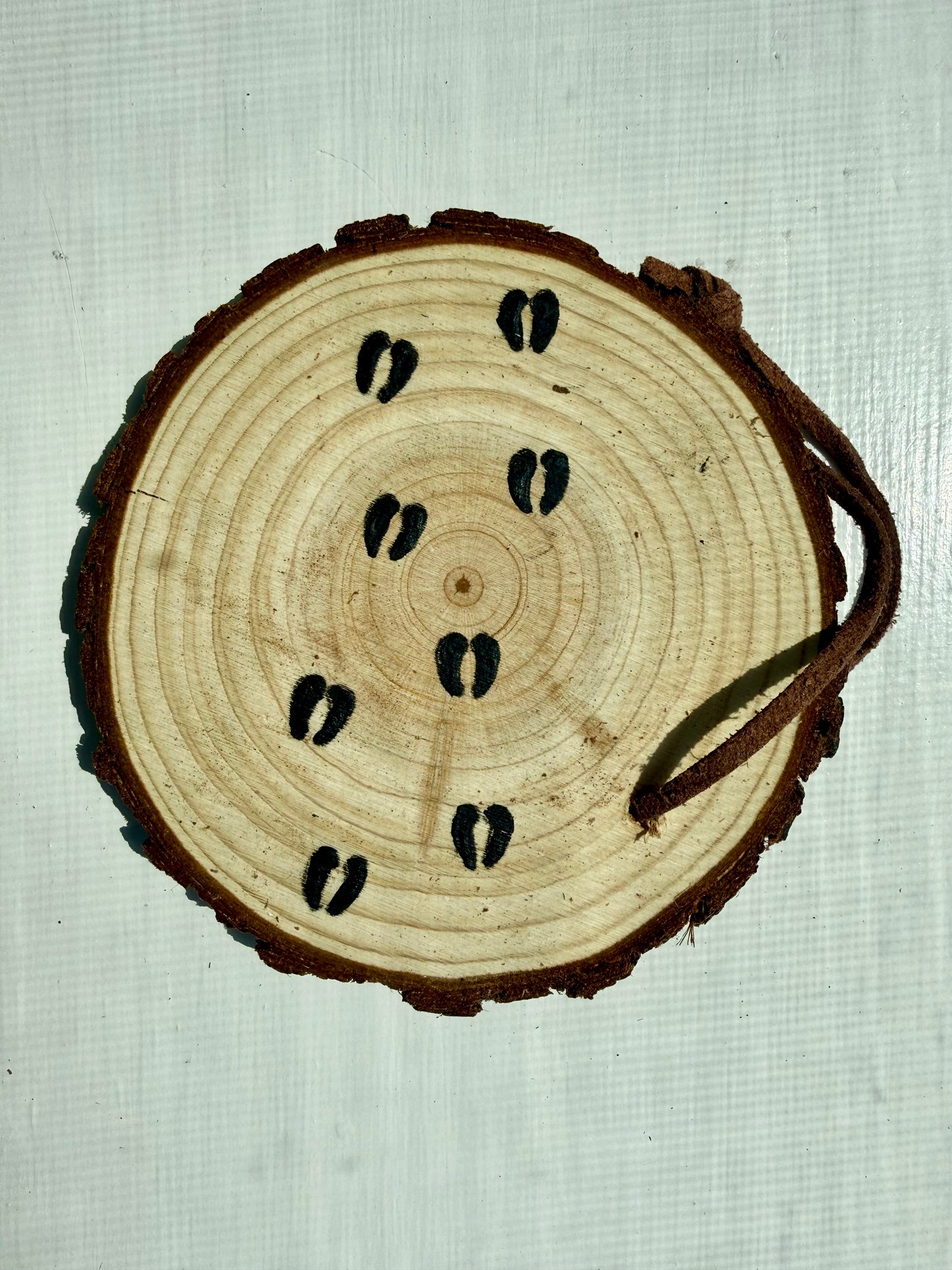 Wooden ornament showcasing bison hoofprints 