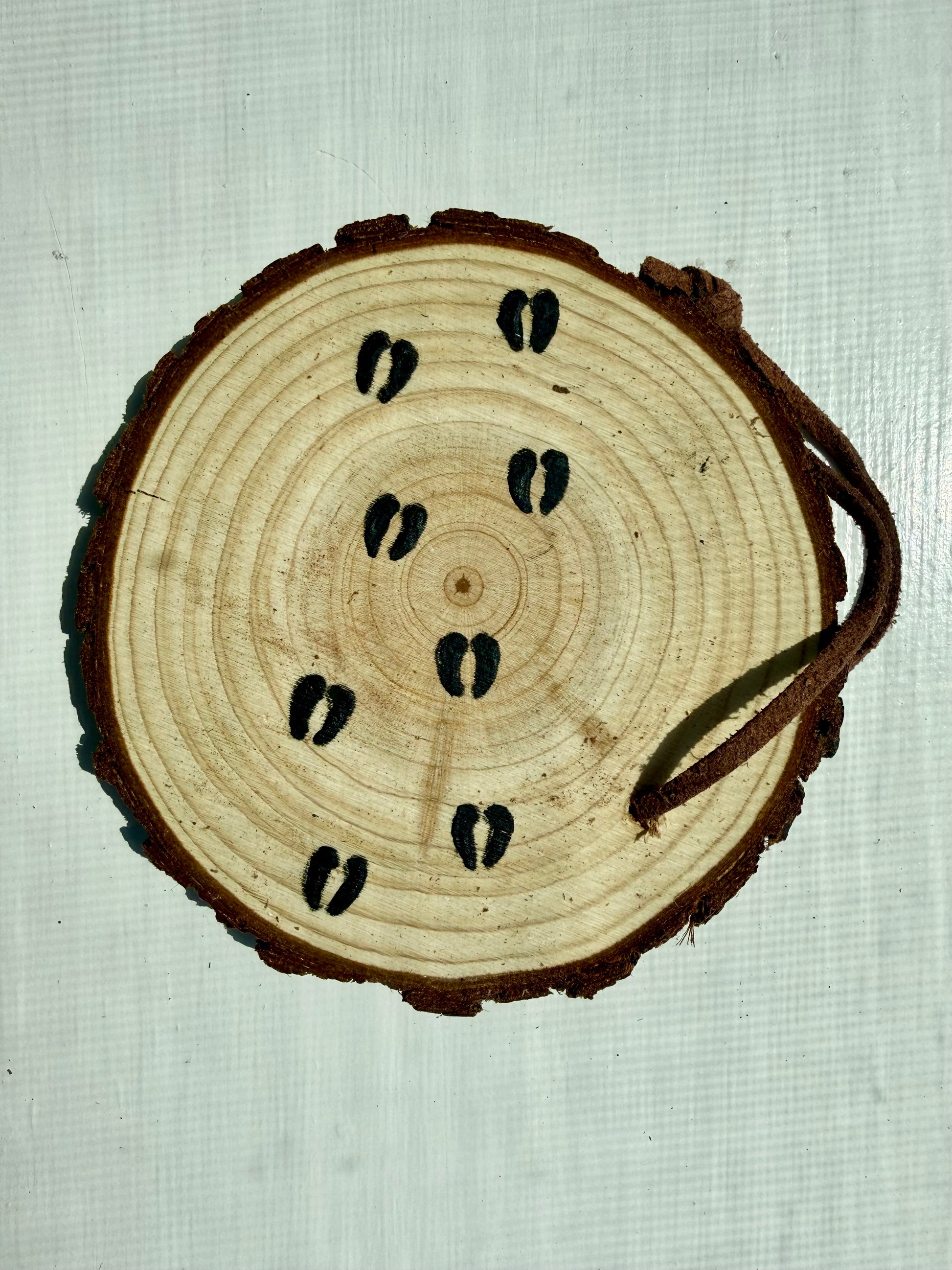 Wooden ornament showcasing bison hoofprints 