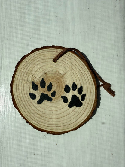 Wooden ornament featuring hand-painted black bobcat tracks
