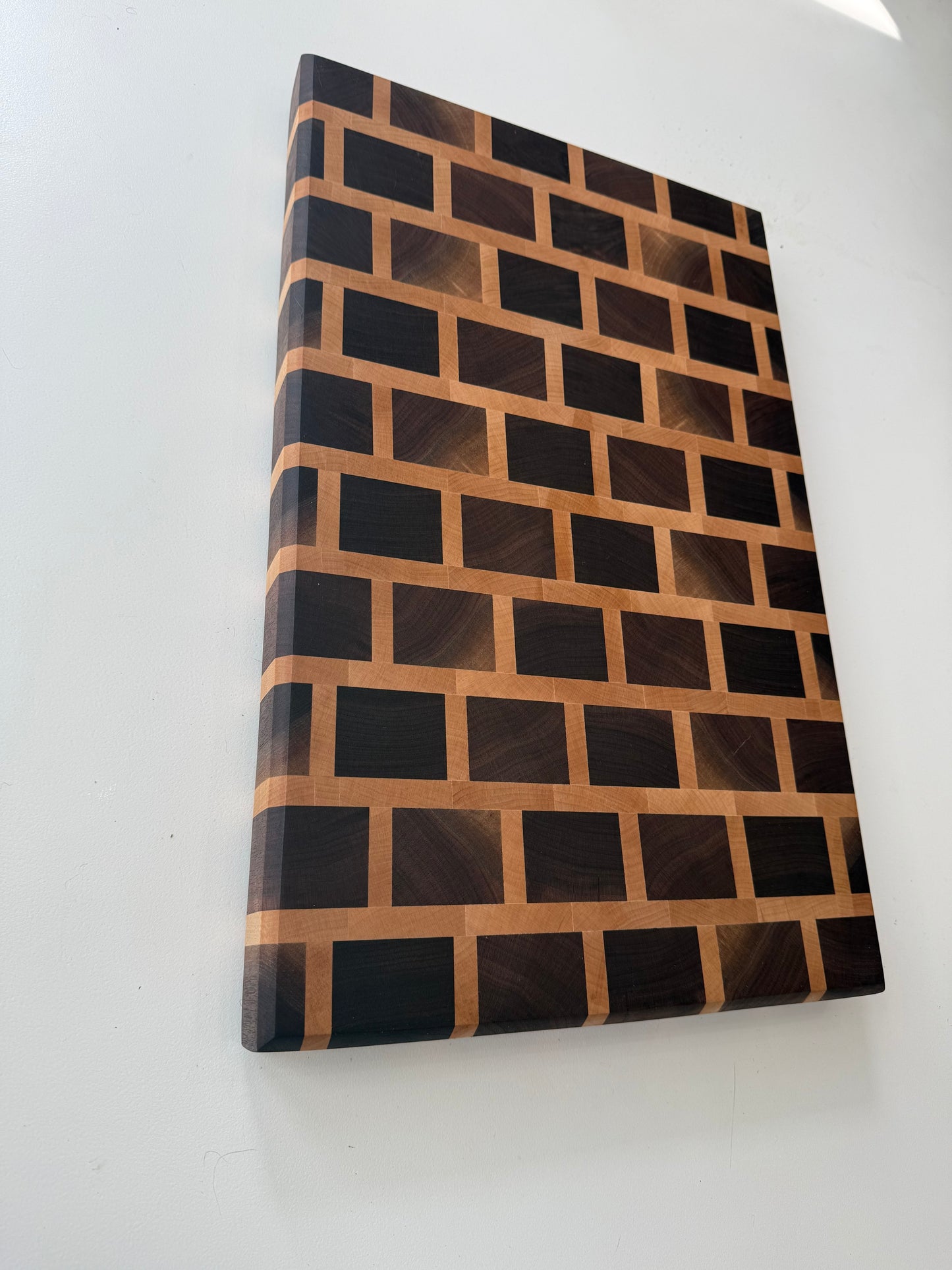 Wooden cutting board with a geometric pattern on a white surface