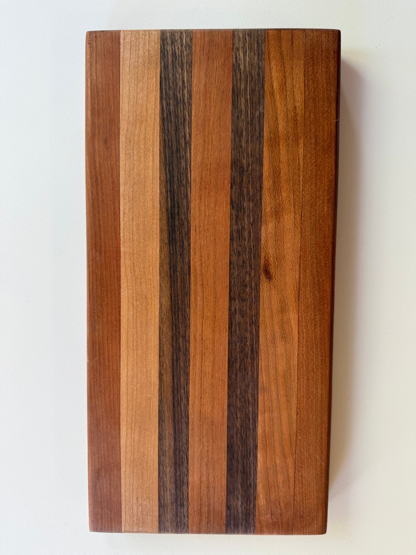 Wooden cutting board with a stripe pattern on a white surface