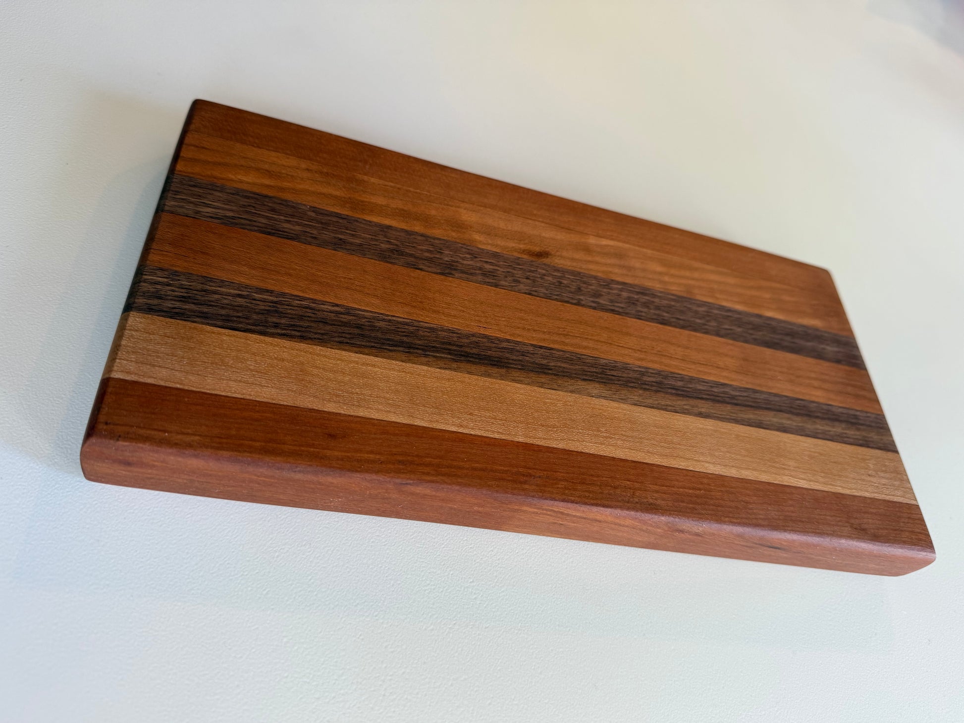 Wooden cutting board with a stripe pattern on a white surface