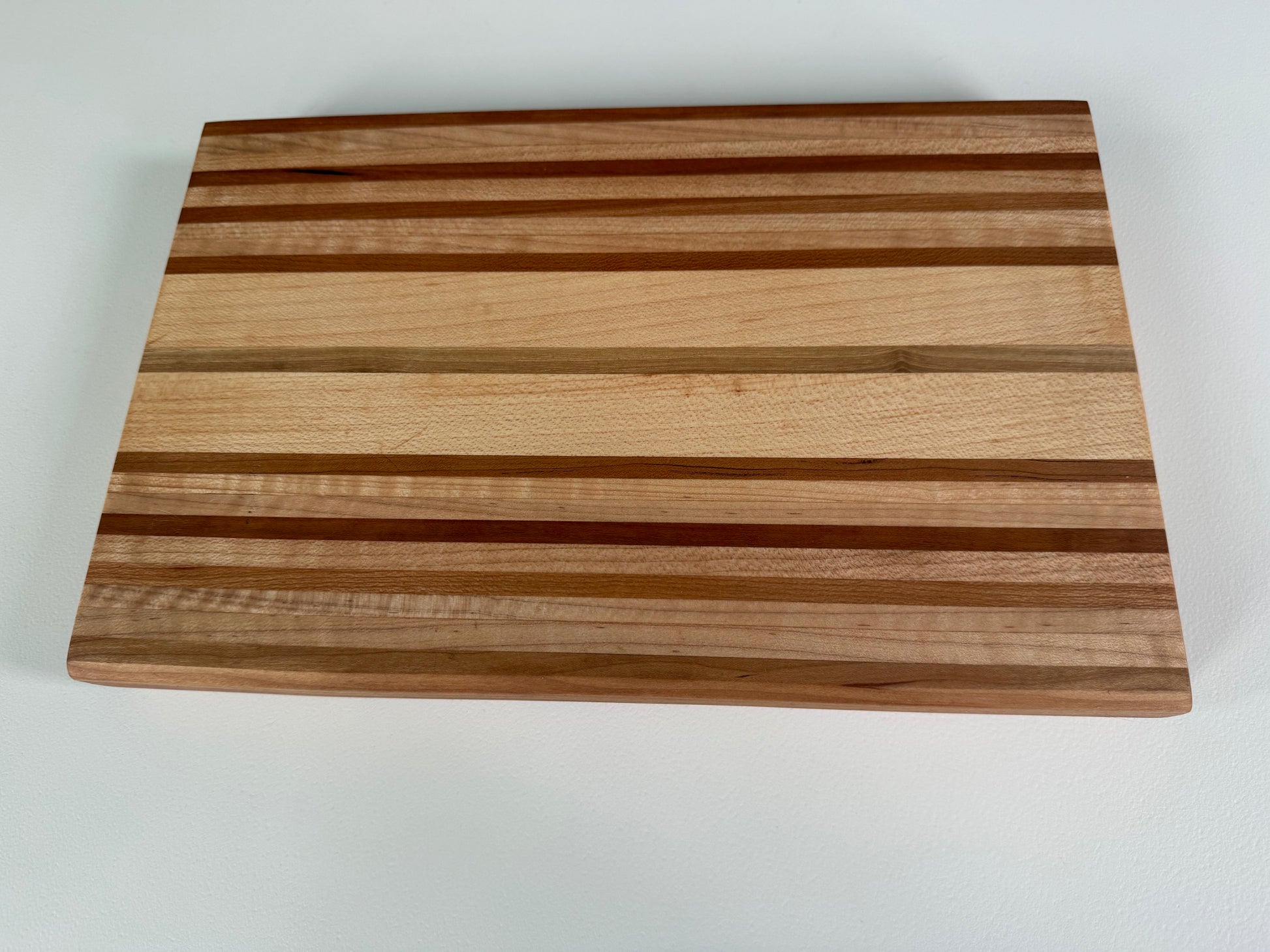 Wooden cutting board with striped pattern on a white background