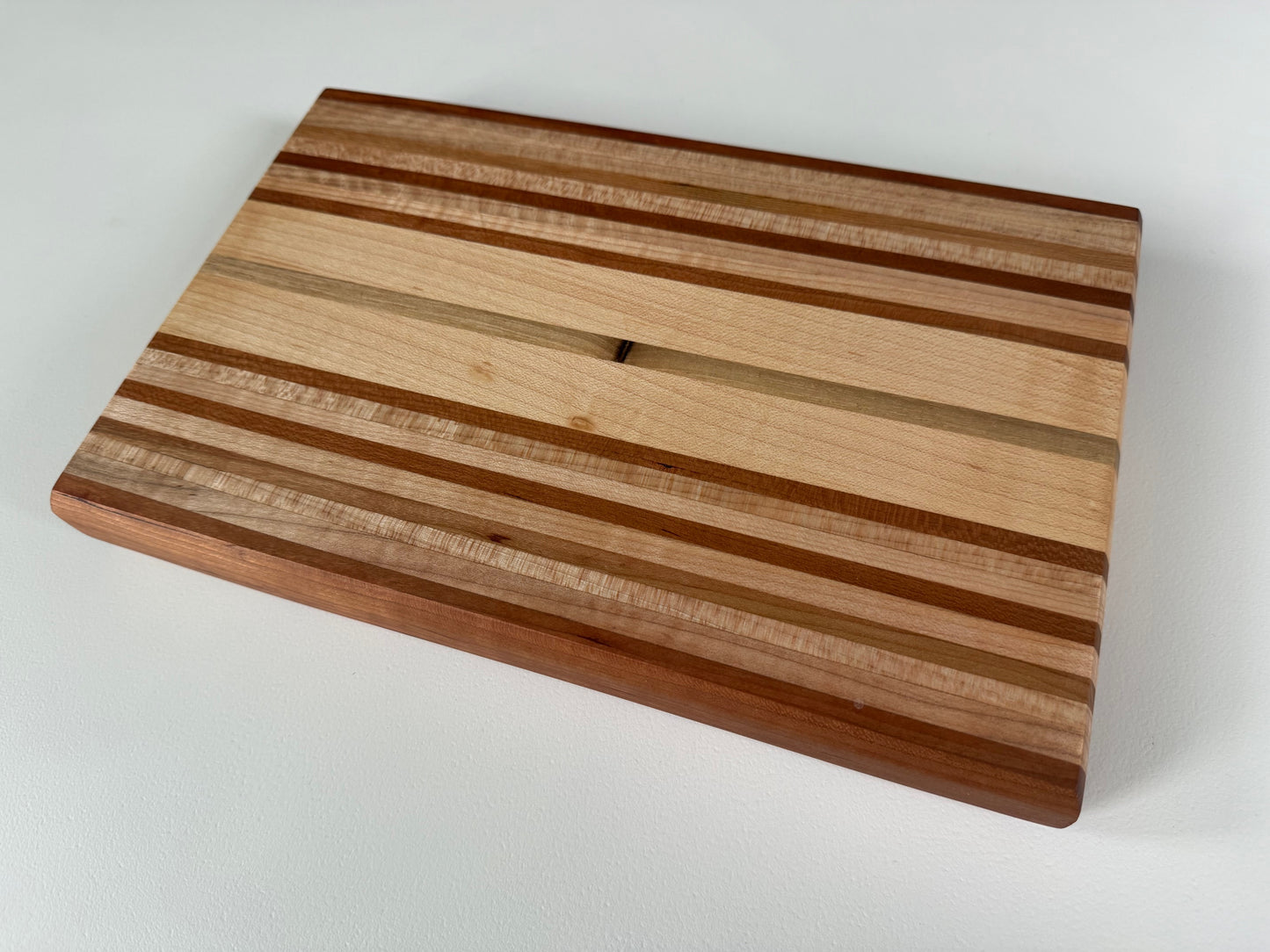 Wooden cutting board with striped pattern on a white background
