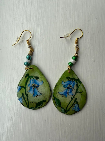 Pair of earrings with floral design on green background