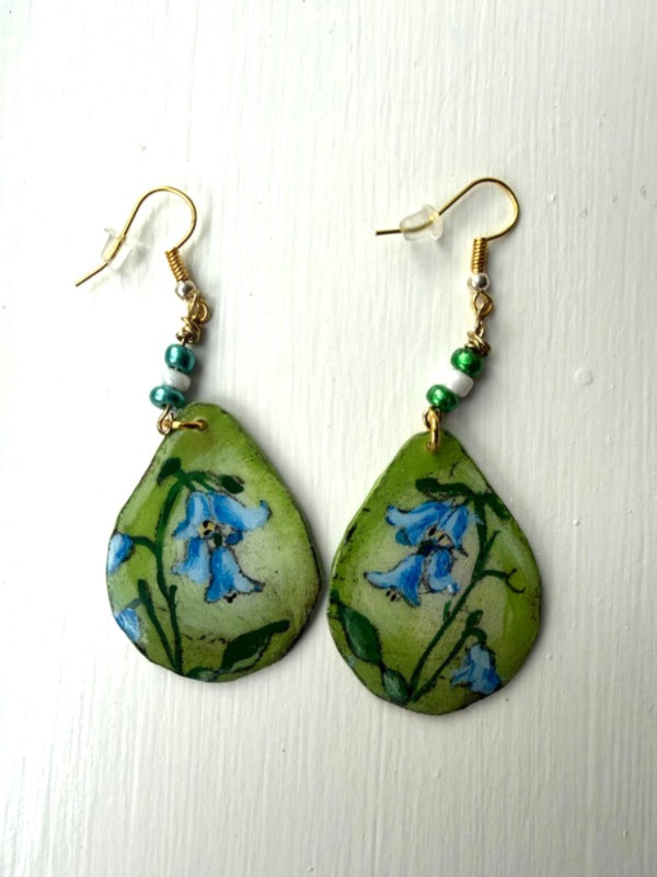 Pair of earrings with floral design on green background