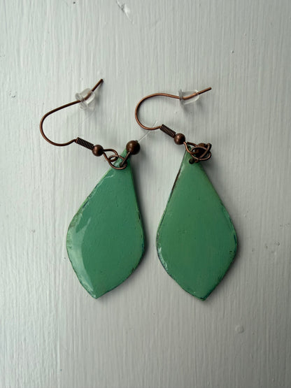 Teardrop-shaped earrings with teal background on each one