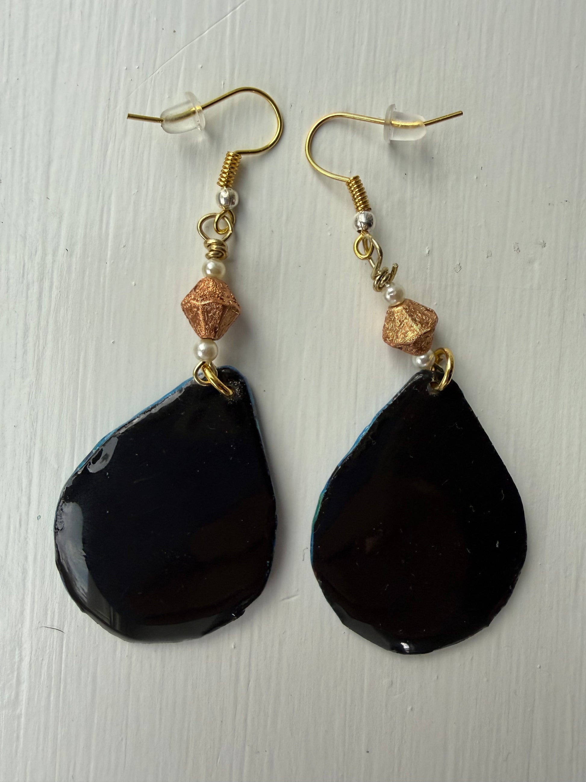 Pair of earrings with solid black background on each one 