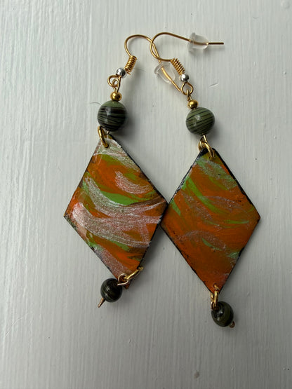 Pair of earrings with green, orange and silver design on each one