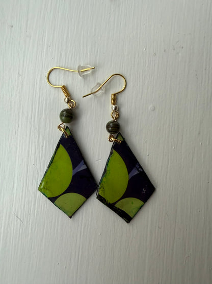 Pair of earrings with green, purple, and black geometric design on each one