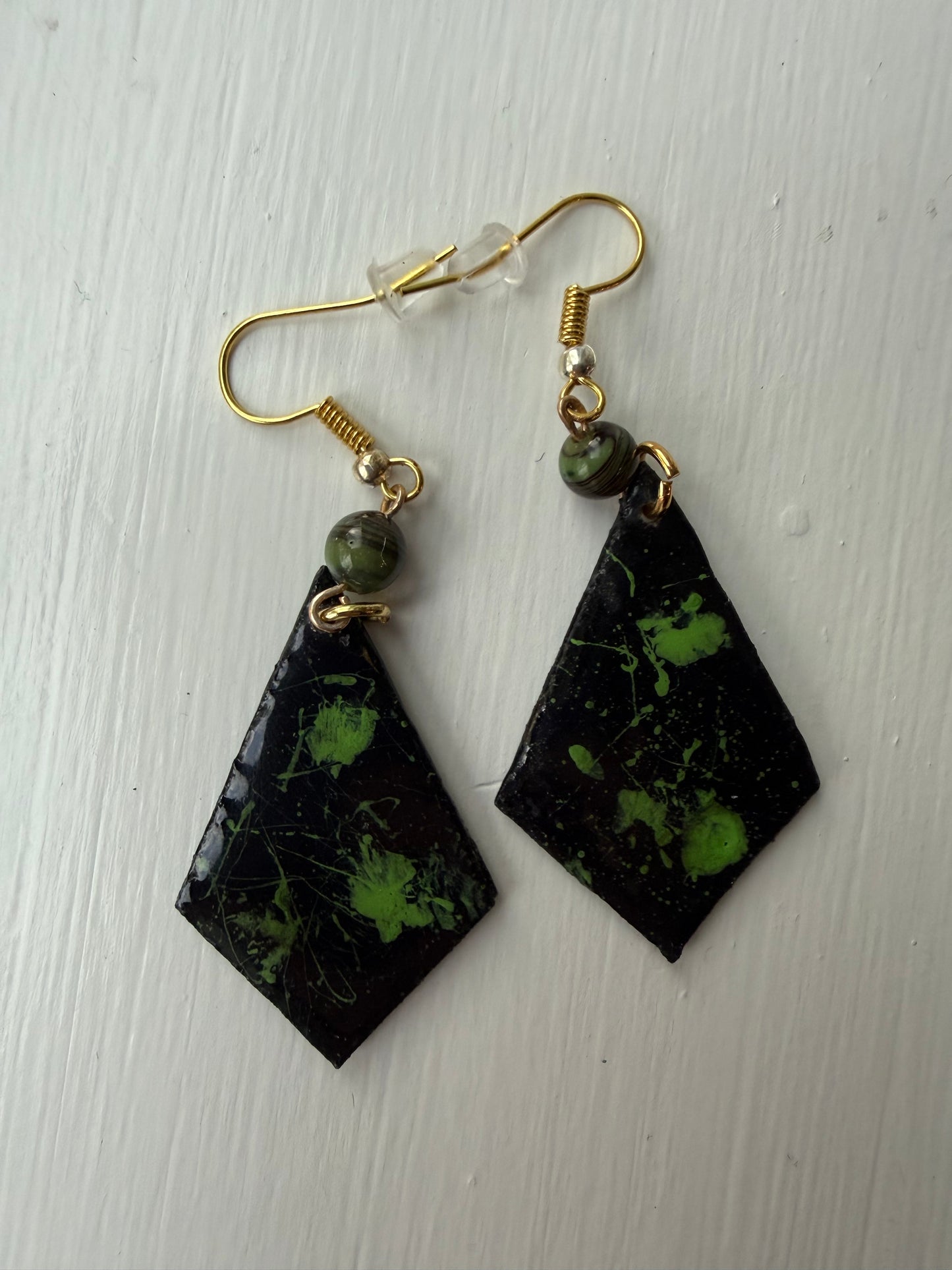 Pair of earrings with black and green marbled design on each one
