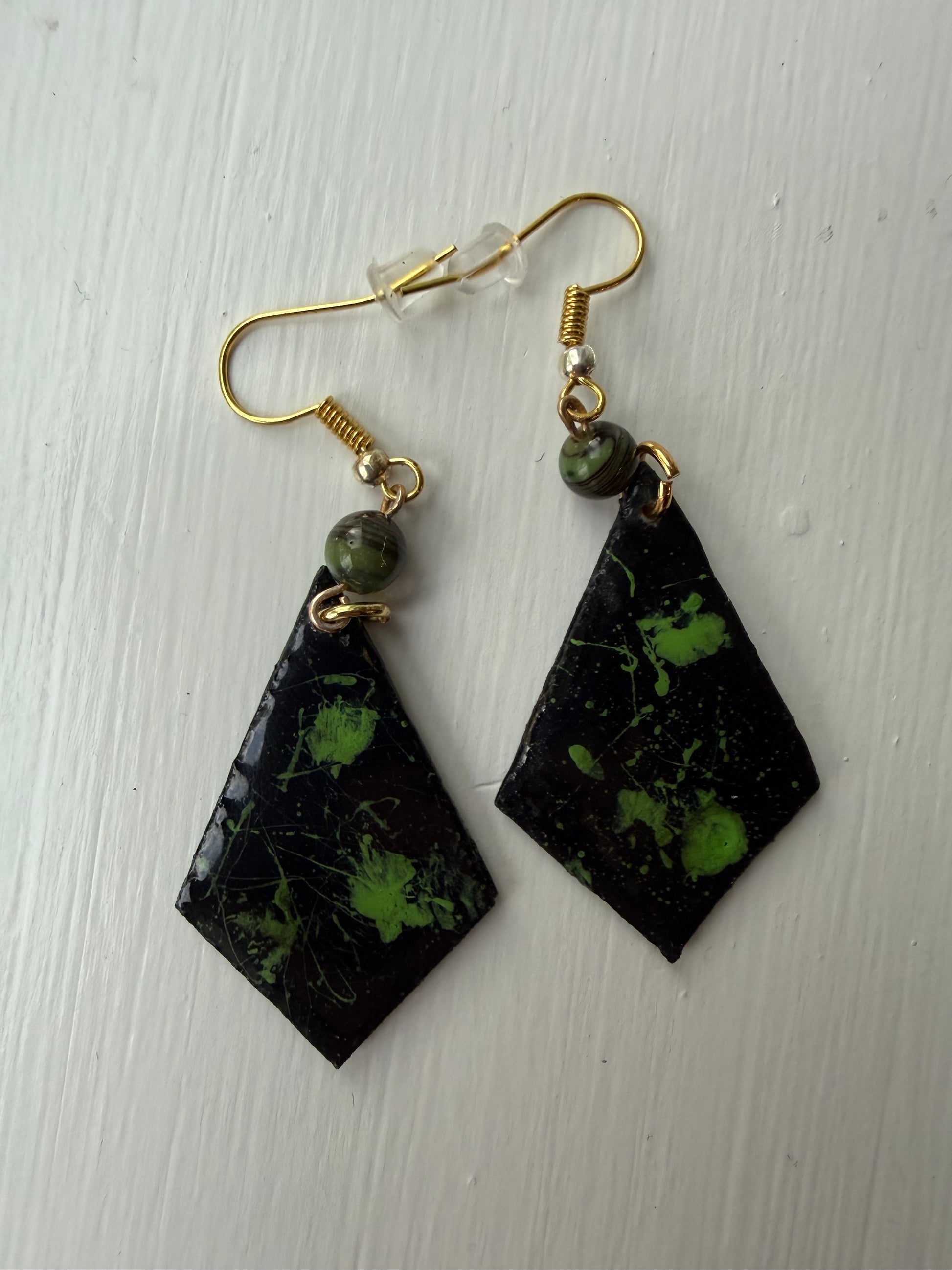 Pair of earrings with black and green marbled design on each one