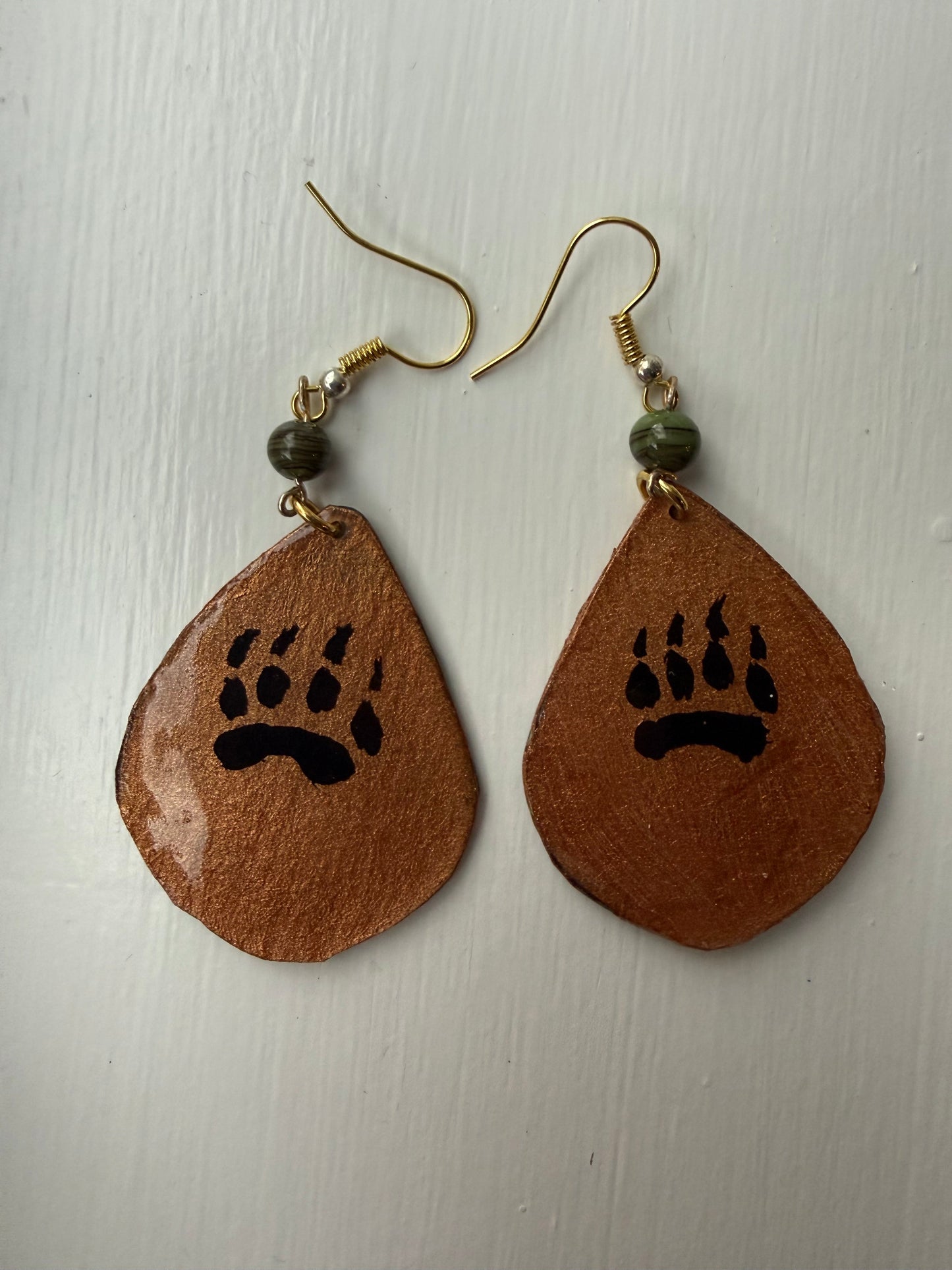 Pair of earrings with an artistic design of a bear paw on each one