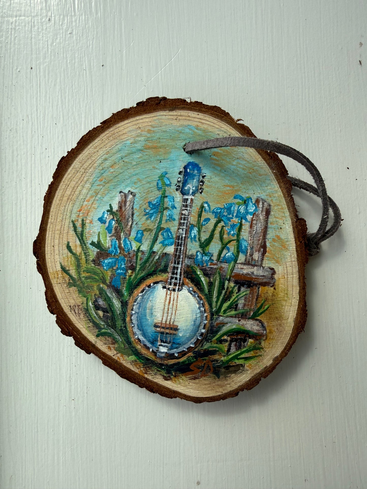 Wooden ornament with a painted banjo and flowers on it