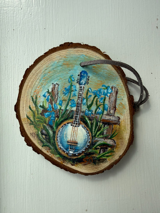 Wooden ornament with a painted banjo and flowers on it