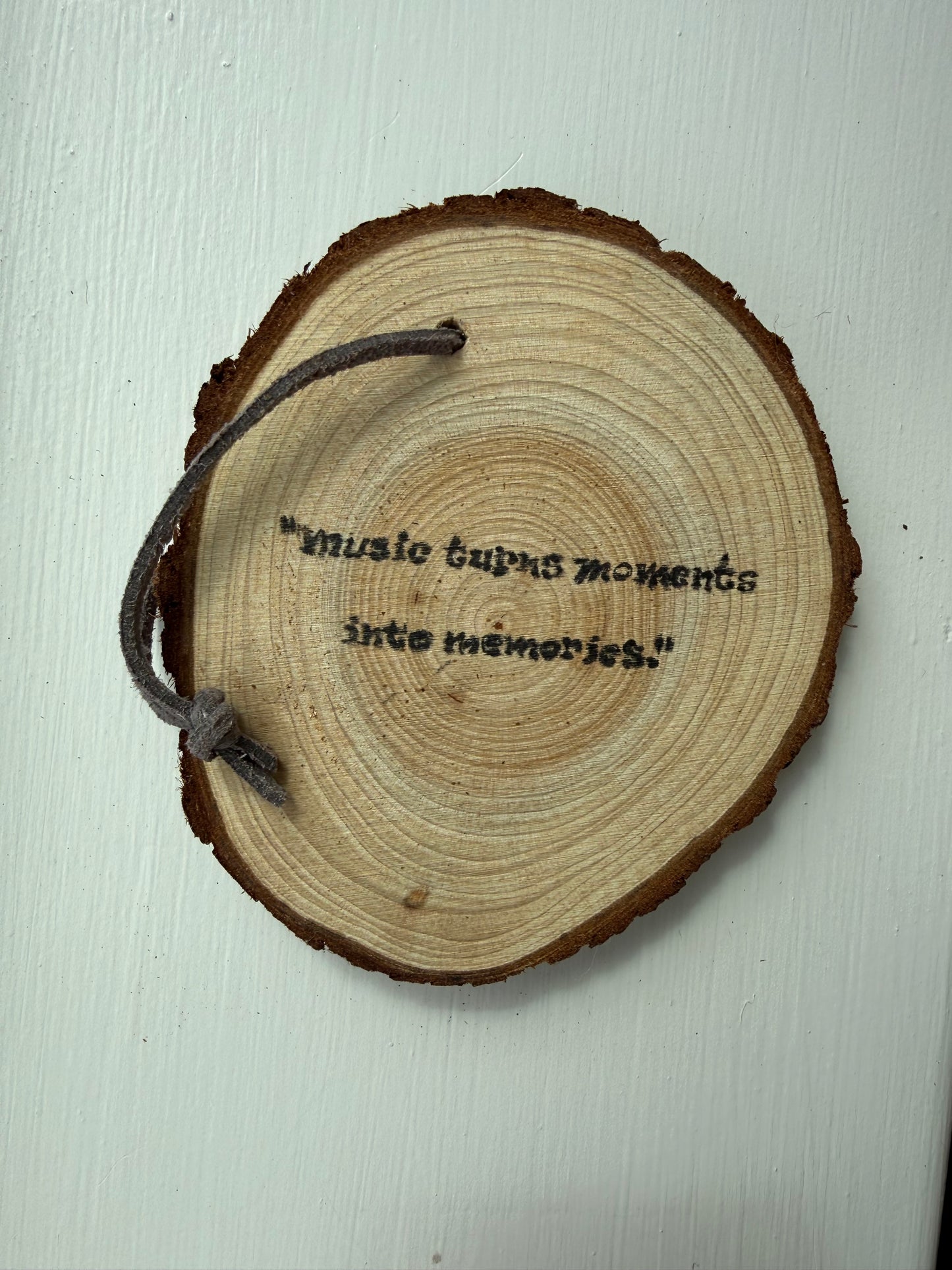 Wooden ornament that says "Music turns moments into memories."