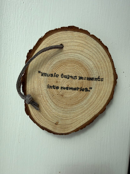 Wooden ornament that says "Music turns moments into memories."