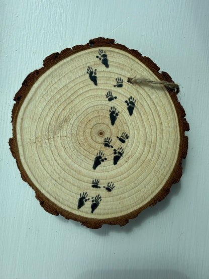 Wooden ornament with painted raccoon tracks on it