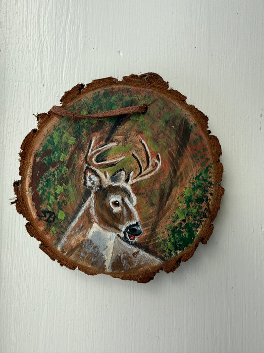 Wooden ornament with a painted deer design on it