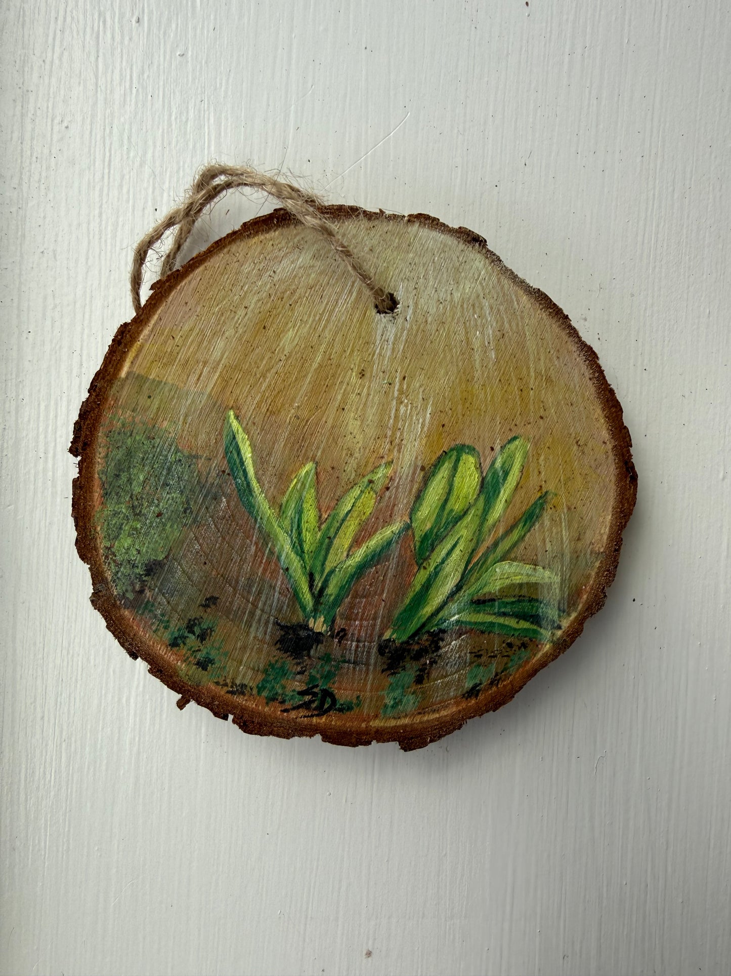 Wooden ornament with painted ramp leaves on a white background