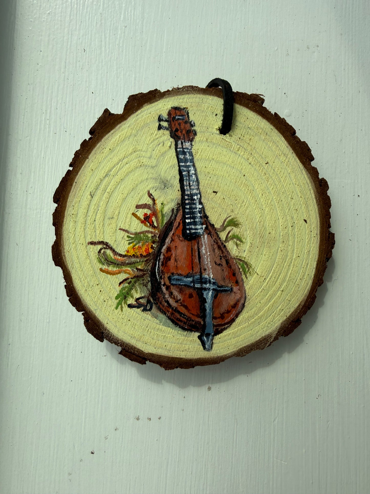 Wooden ornament with a painted mandolin design on it