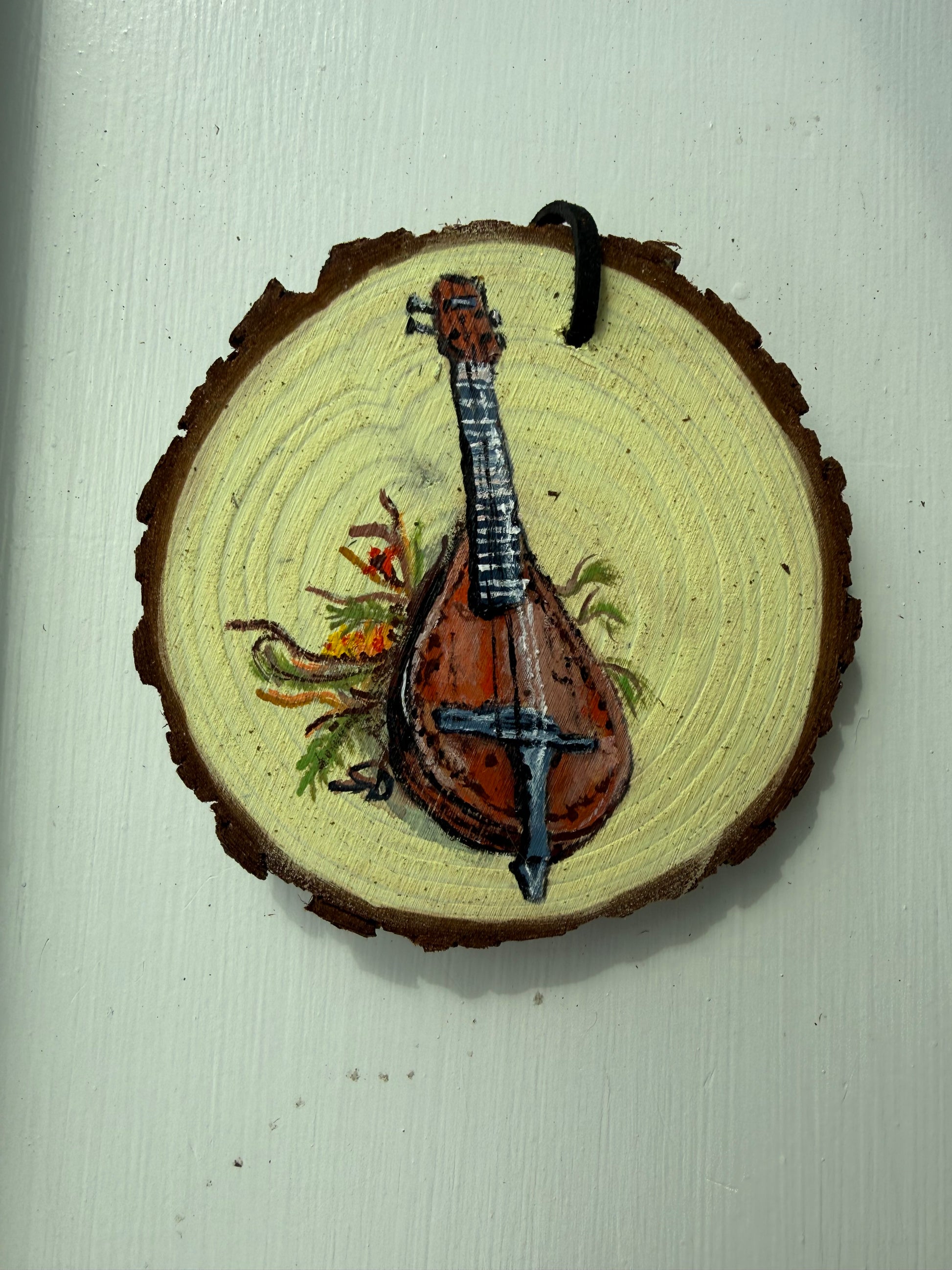Wooden ornament with a painted mandolin design on it