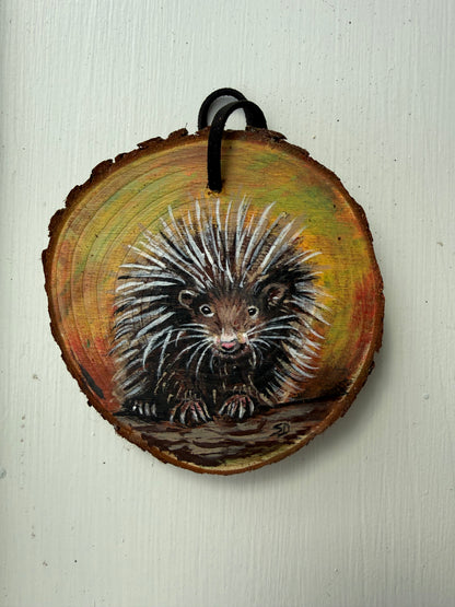 Wooden ornament with painted porcupine on it
