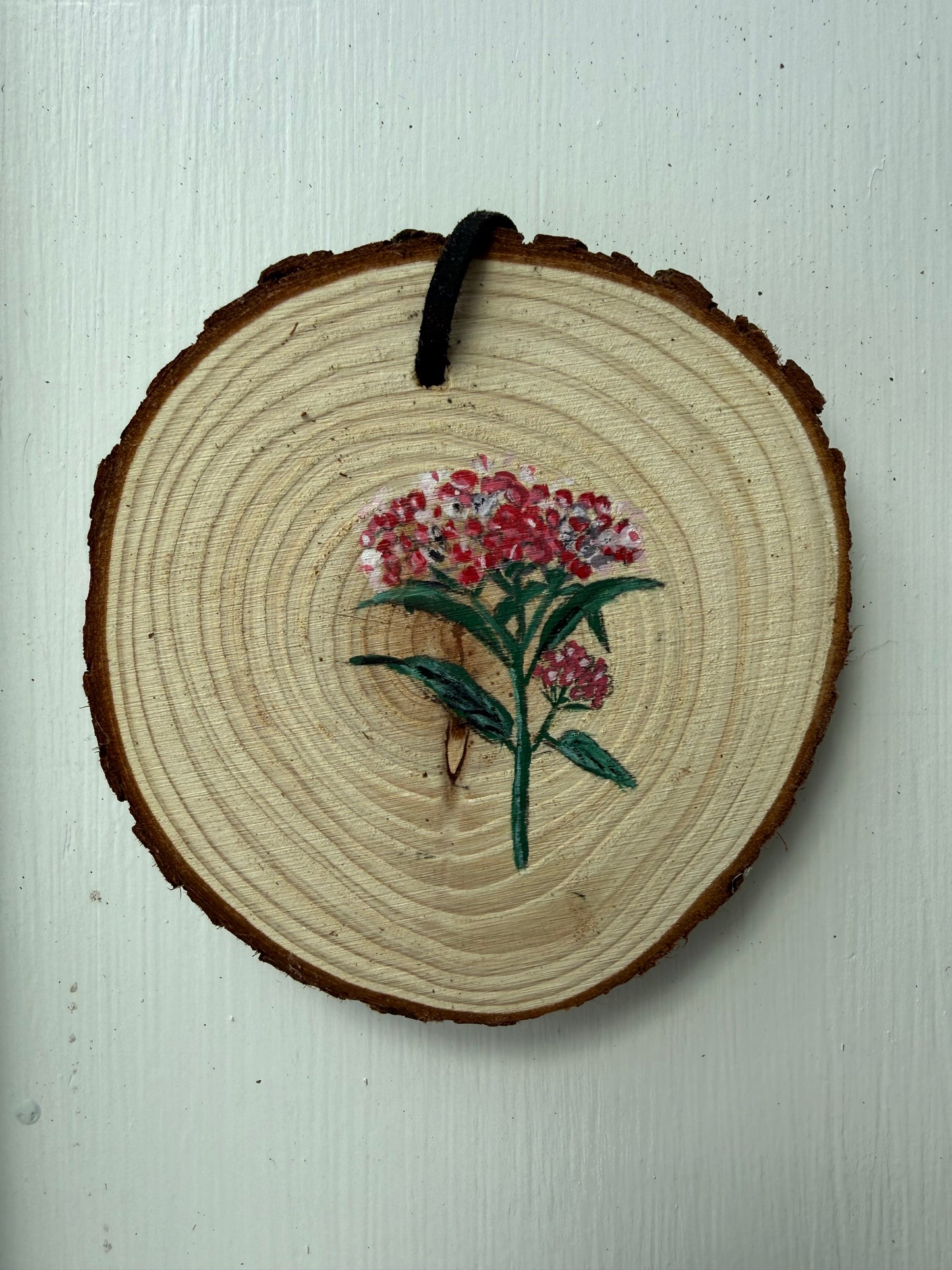 Wooden ornament with a painted floral design on it