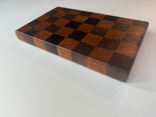 Square cutting board with a checkered cherry and walnut wood design