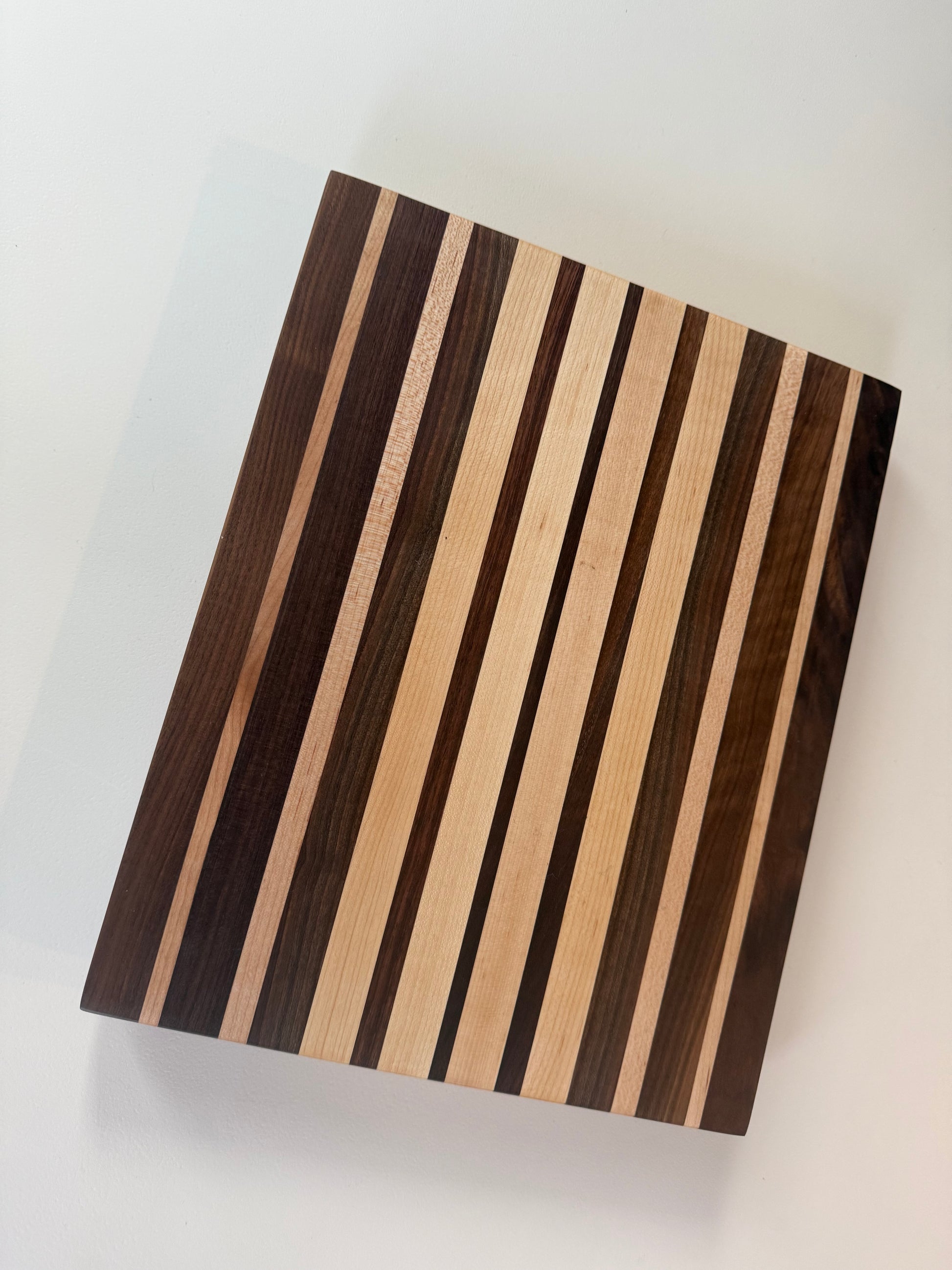 Wooden cutting board with striped pattern on a white background