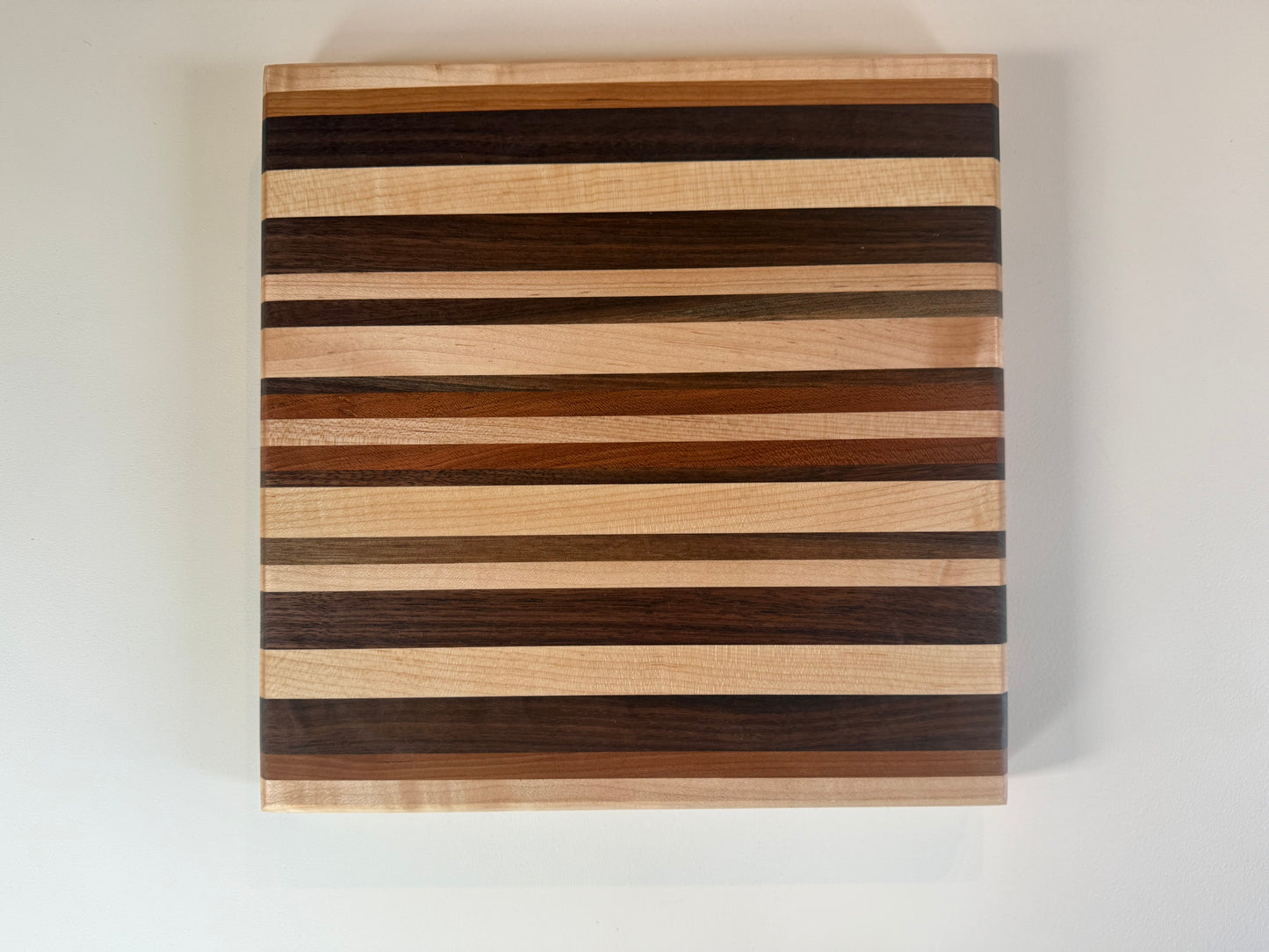 Wooden cutting board with striped pattern on a white background