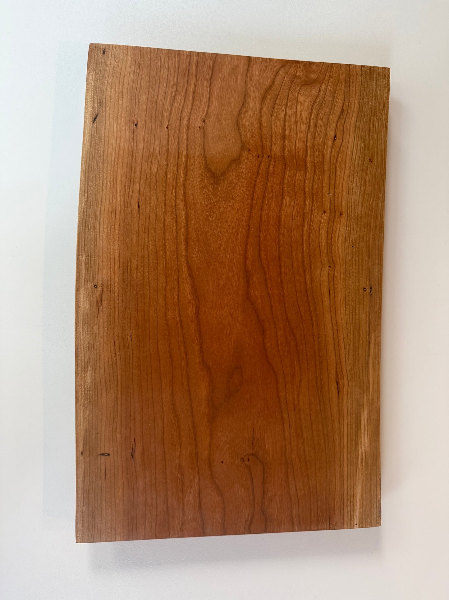 Wooden charcuterie board with live edge on a white background