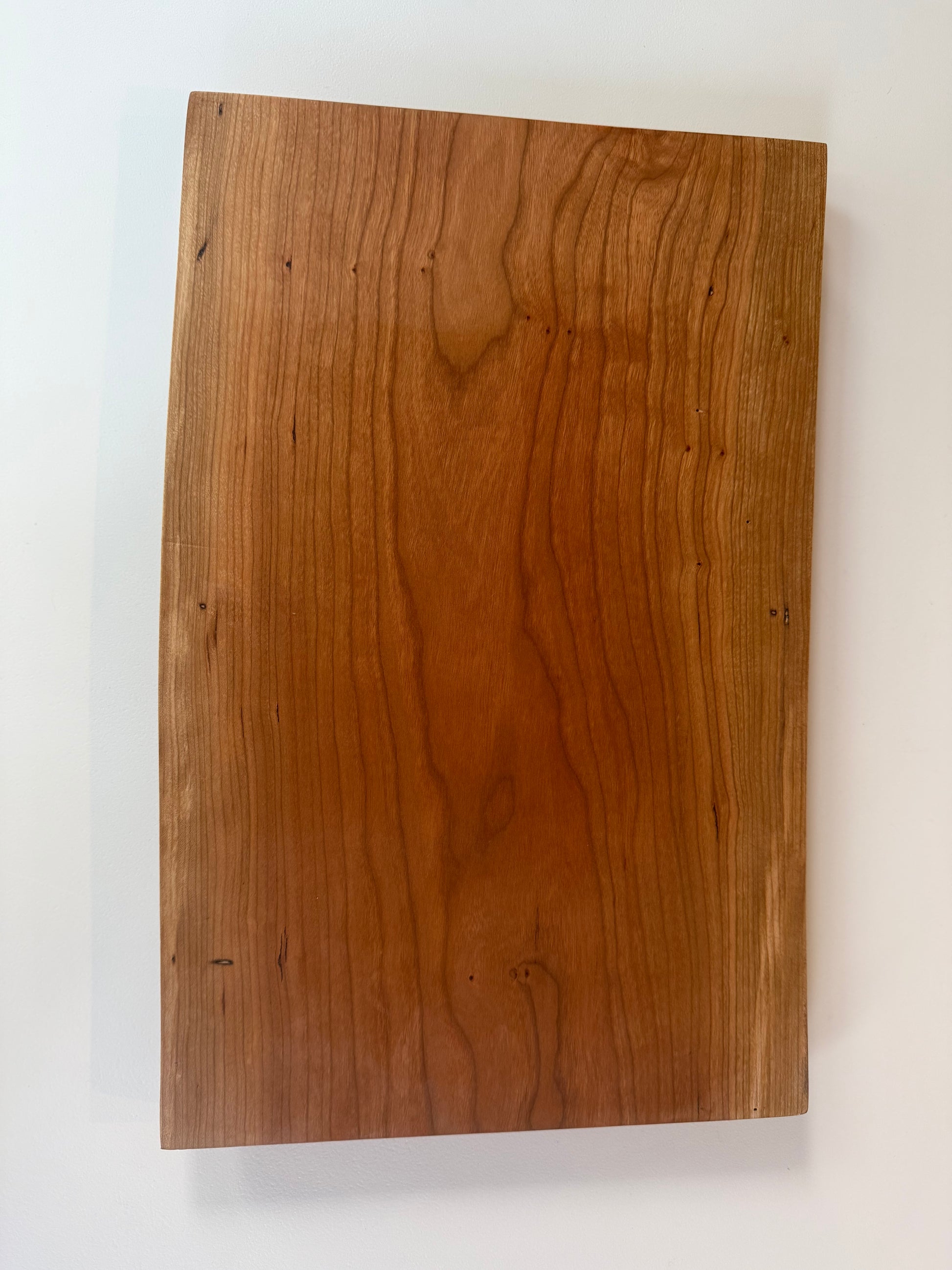 Wooden charcuterie board with live edge on a white background