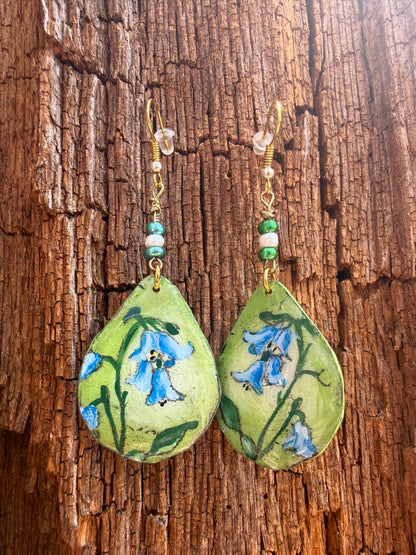 Pair of earrings with floral design on a wooden surface