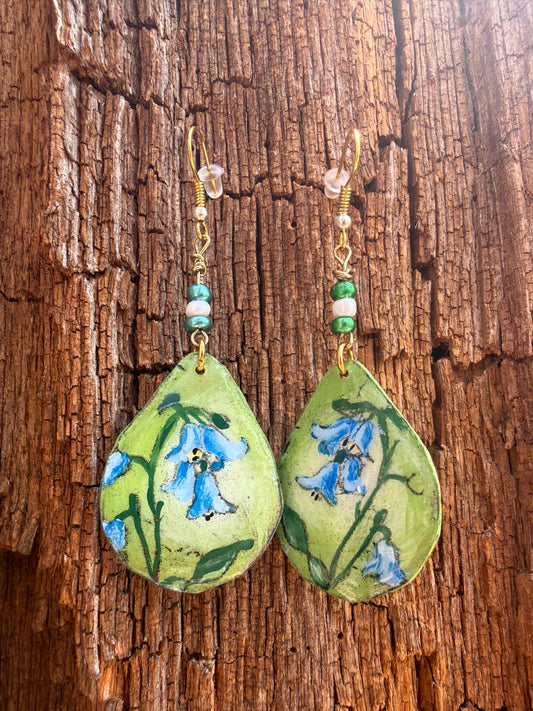 Pair of earrings with floral design on a wooden surface