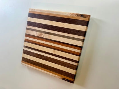 Wooden cutting board with striped pattern on a white surface