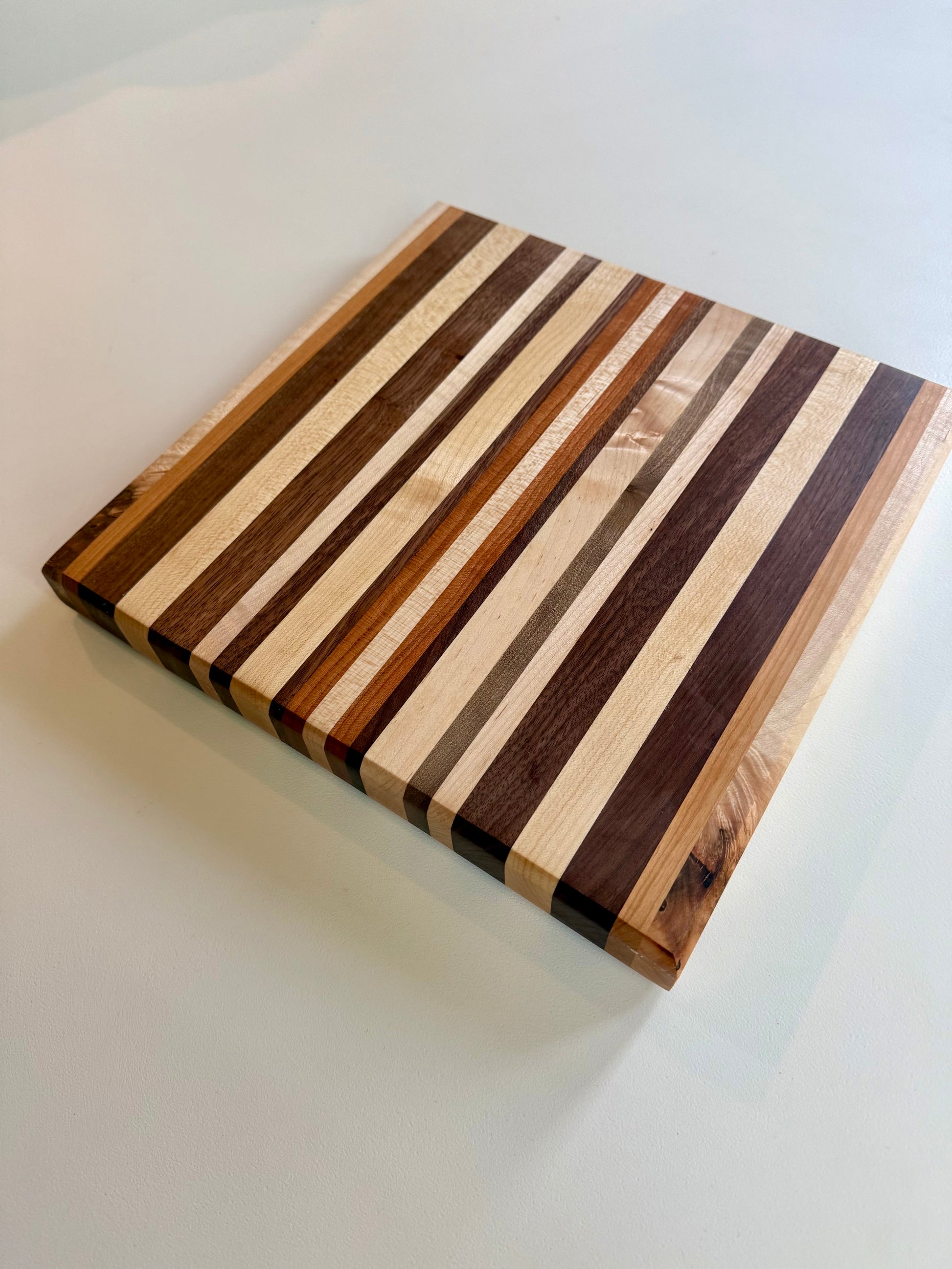 Wooden cutting board with striped pattern on a white surface
