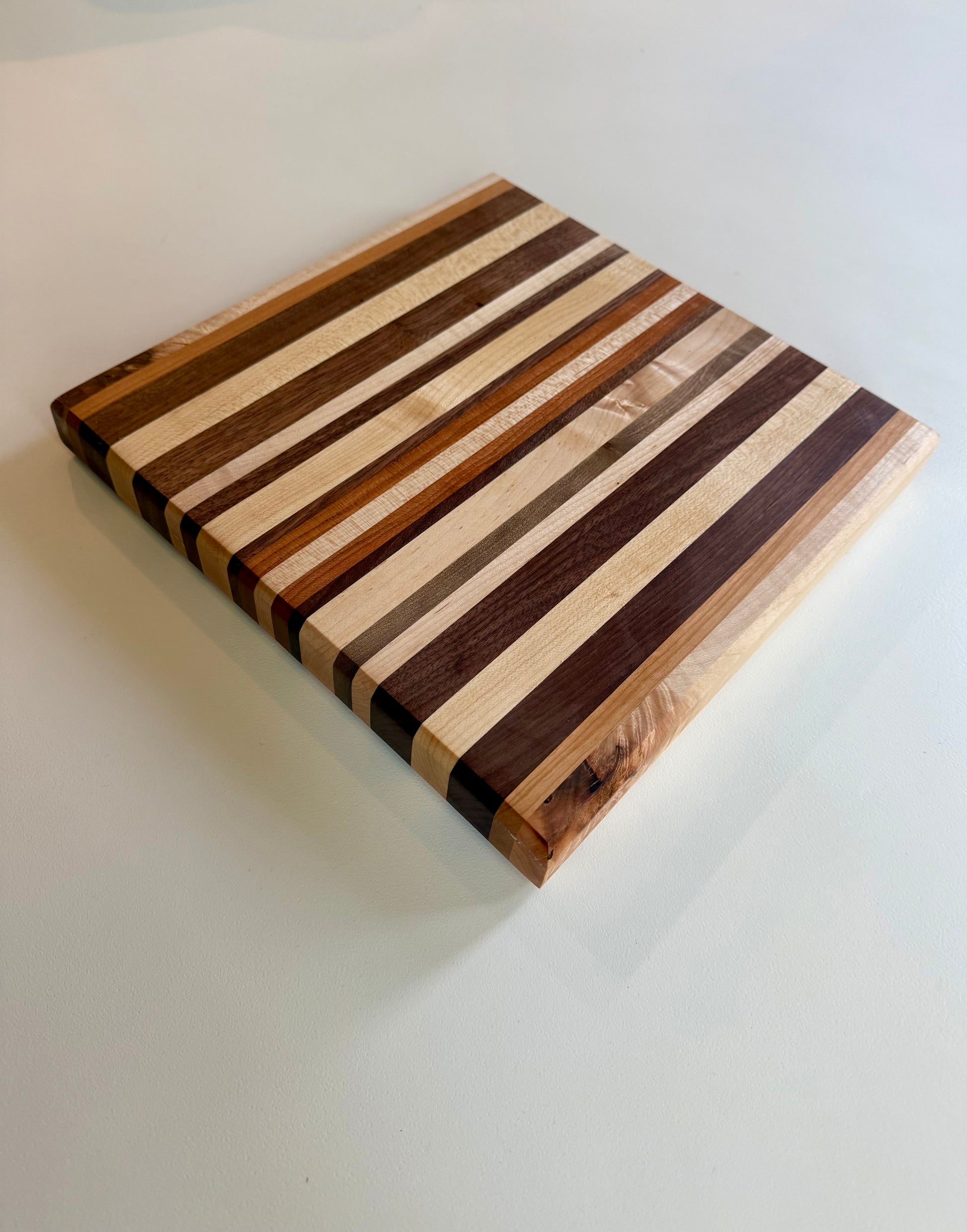Wooden cutting board with striped pattern on a white surface