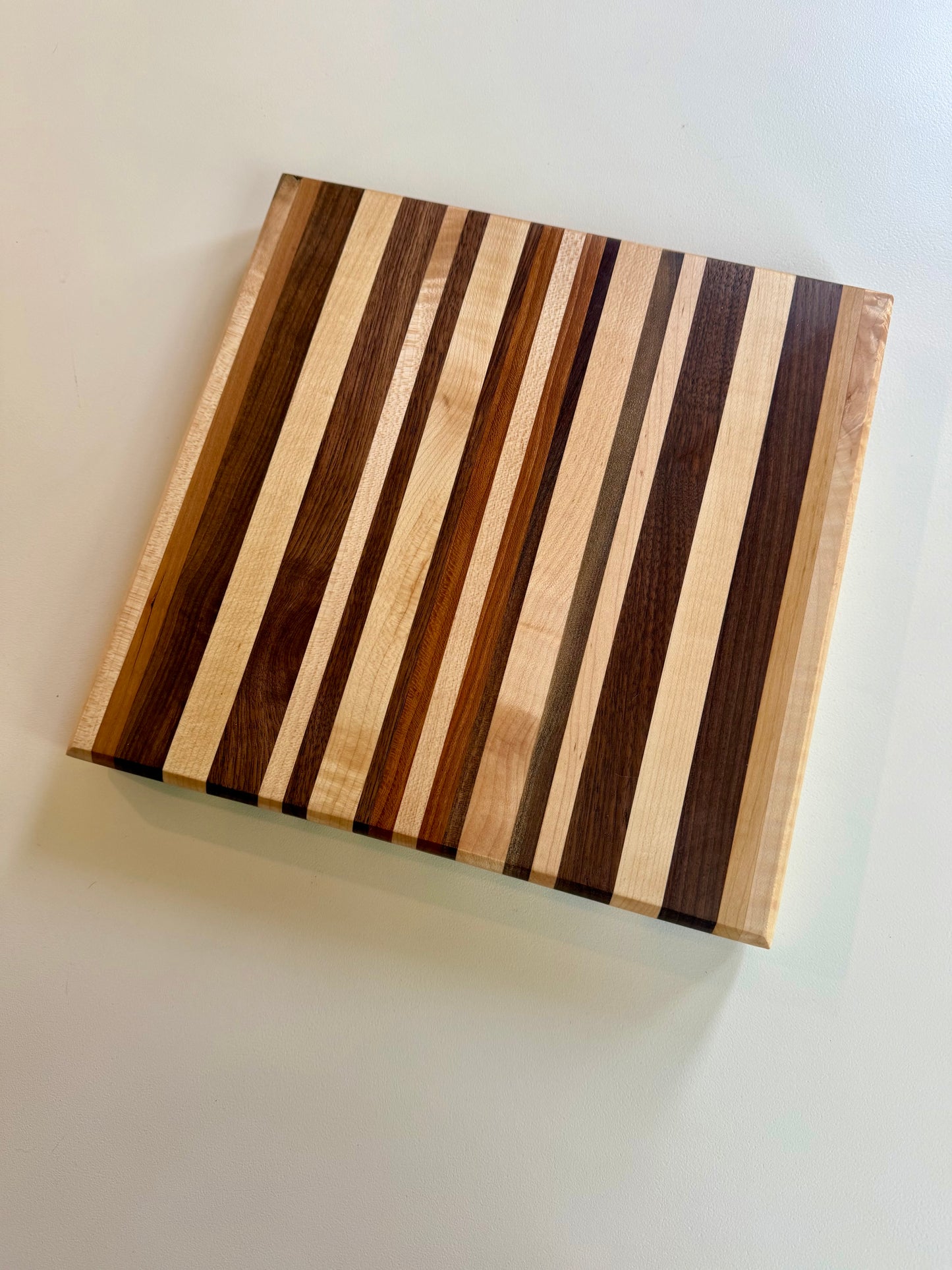Wooden cutting board with striped pattern on a white surface
