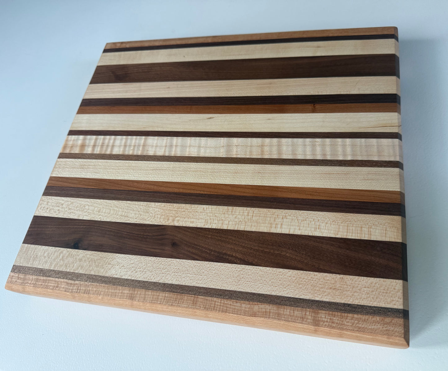 Wooden cutting board with striped pattern on a white background