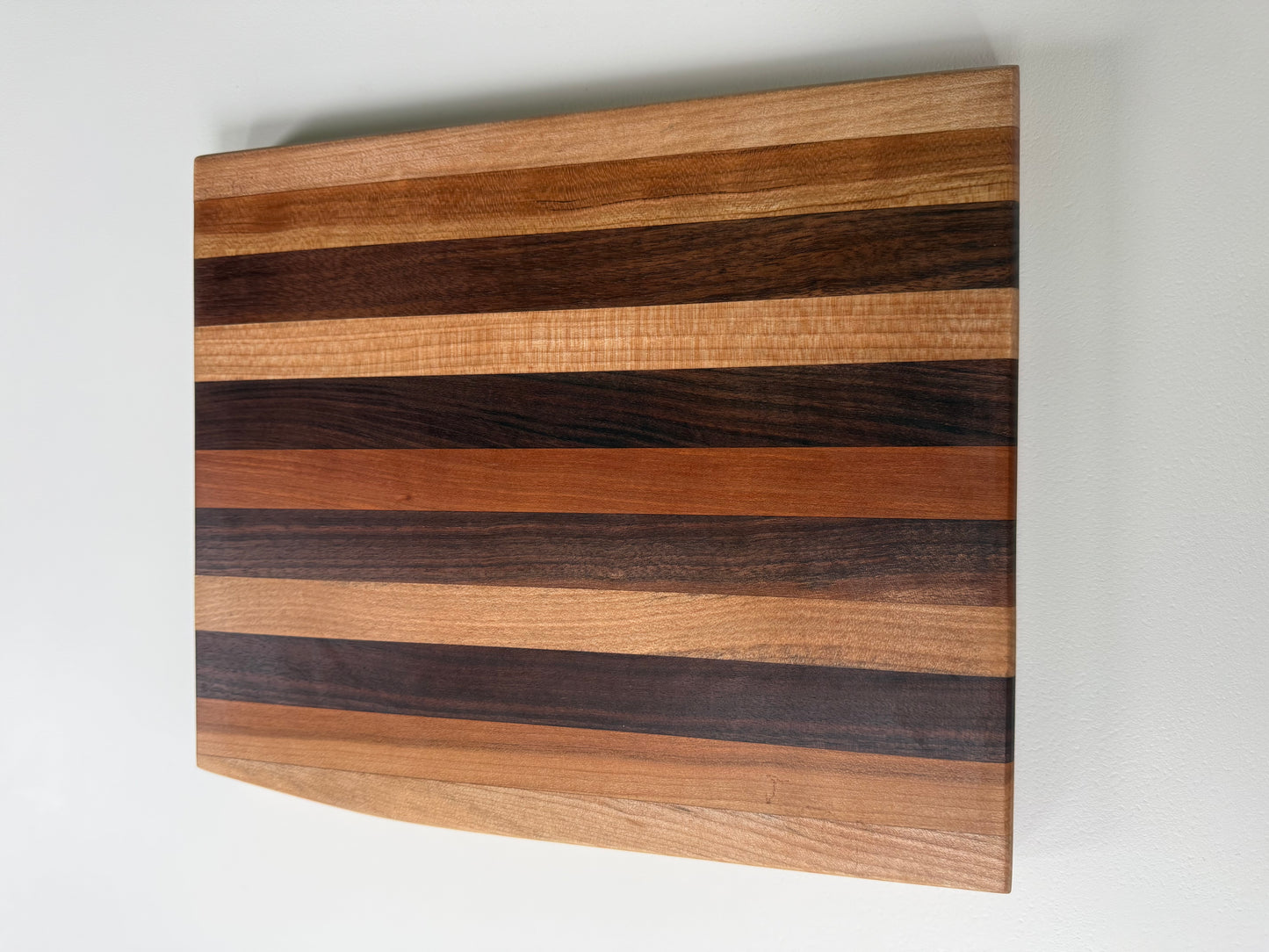 Wooden cutting board with striped pattern on a white background