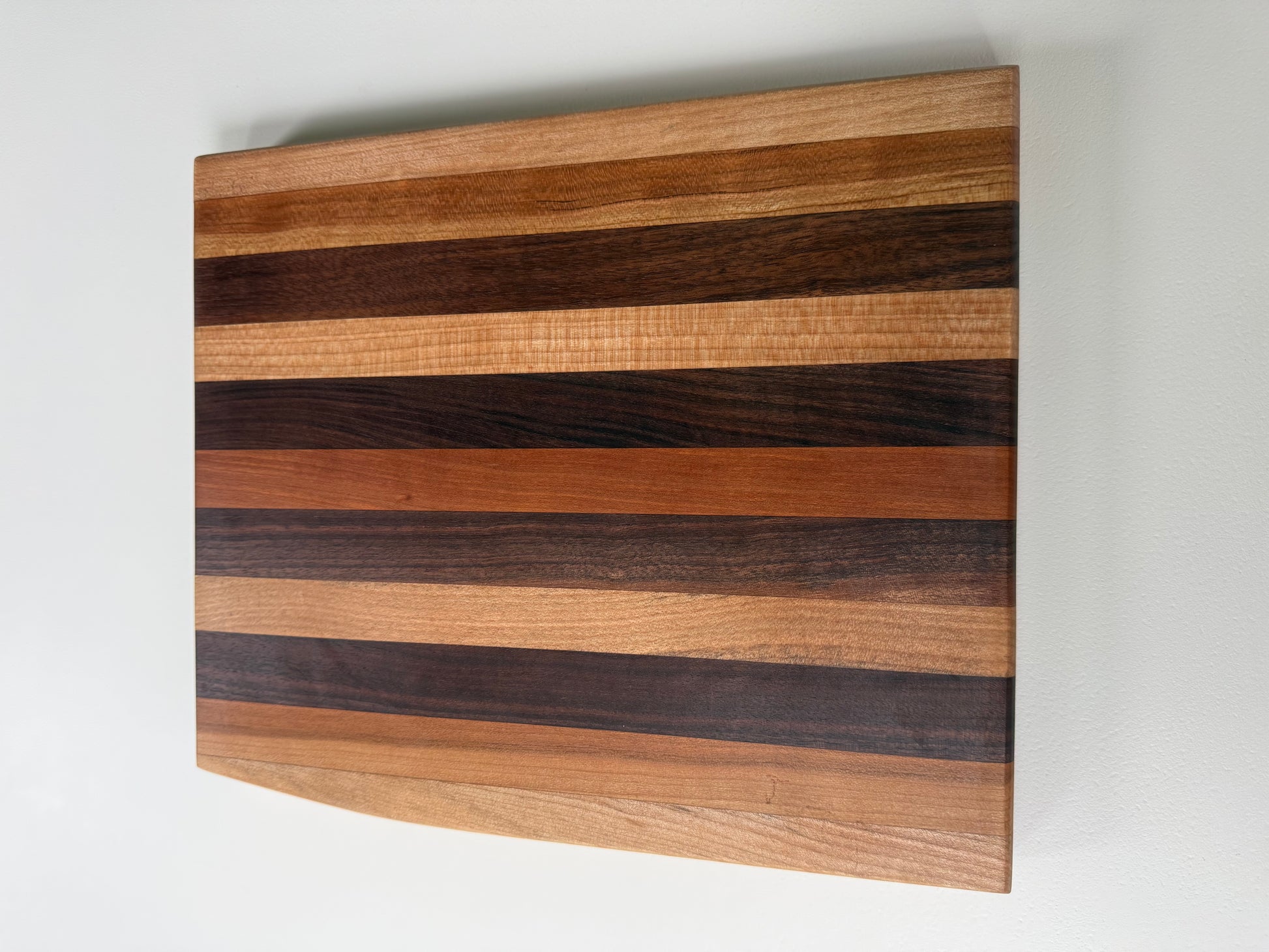 Wooden cutting board with striped pattern on a white background