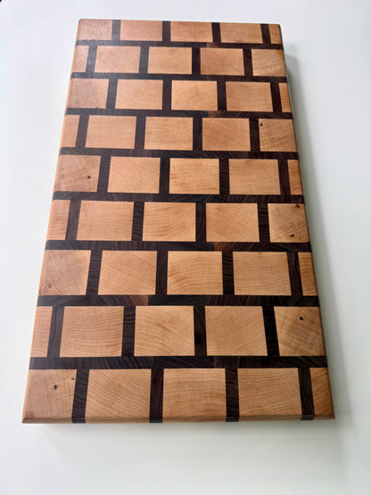 Wooden cutting board with a checkered pattern on a white background